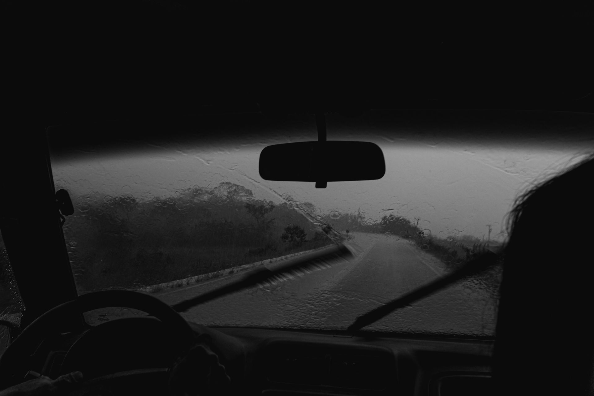 Automobilio valytuvai valo lietaus lašus nuo priekinio stiklo važiuojant rudens lietuje.